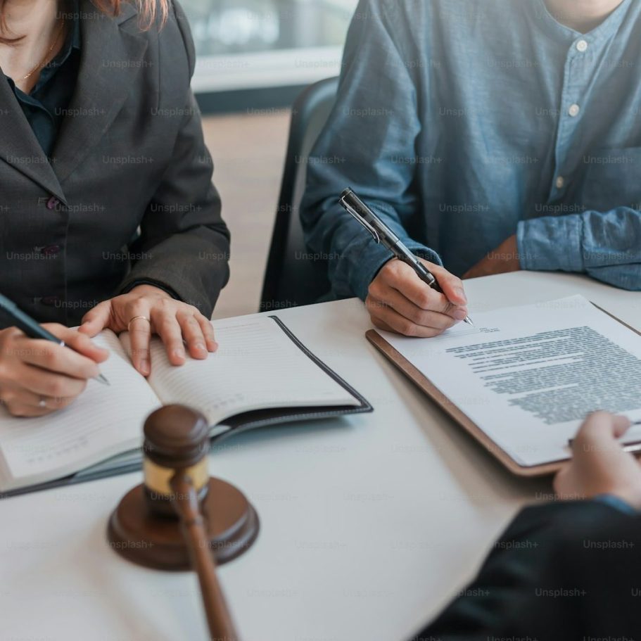 Direction RivierX Réunion de personnes signant des documents avec un maillet de tribunal sur la table.