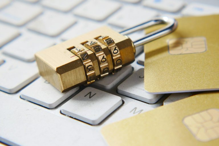 Cadenas à combinaison sur un clavier avec des cartes de crédit à côté.